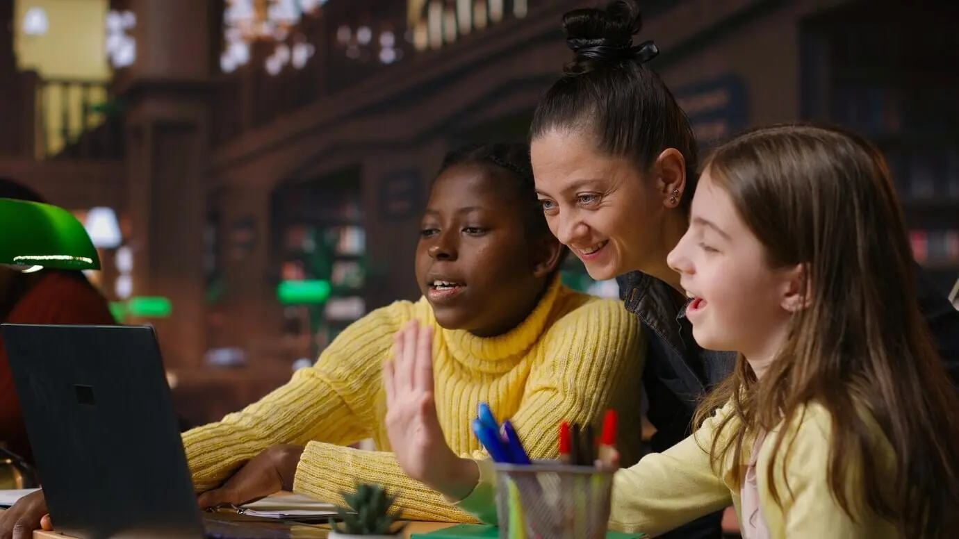 Multiethnische Studierende in der Bibliothek, die im Fernunterricht mit ihrem Mentor lernen.